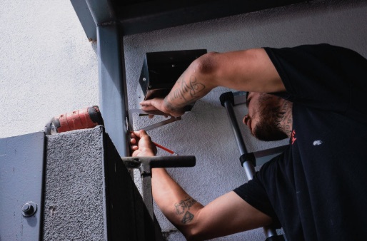 Technician fitting a unit into an overhead steel beam